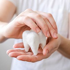 Close-up of someone holding and protecting a giant tooth