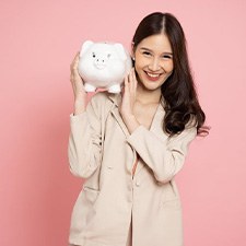 Woman smiling while holding a piggy bank