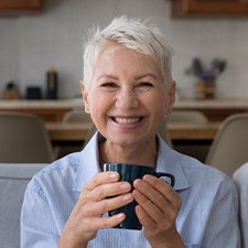 Woman smiling while holding a mug of coffee