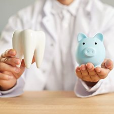 a model tooth and a piggy bank