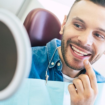 Male patient smiling at reflection at dentist's appointment