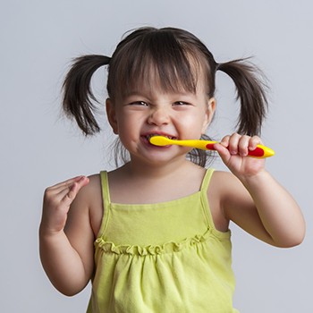 Little girls brushes her teeth before visiting Allen children’s dentist