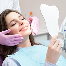 A woman admiring the effects of her cosmetic dental care