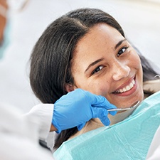 a smiling woman having her teeth examined