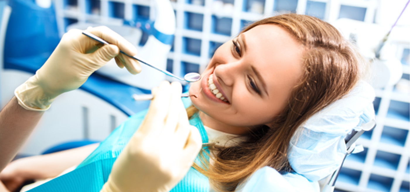 Patient in dental chair smiling at dentist
