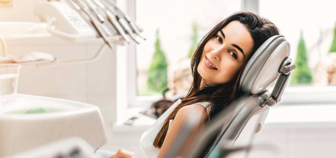 Woman in dental chair smiling after root canal therapy