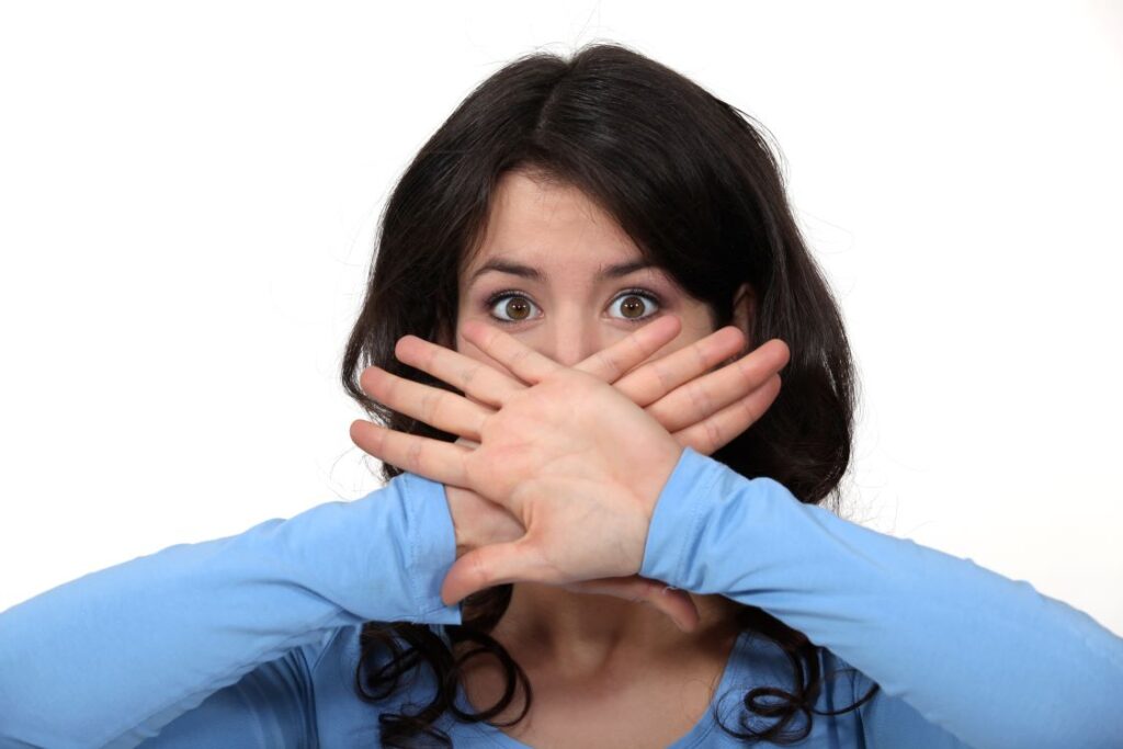 A woman covering her mouth and hiding her smile.